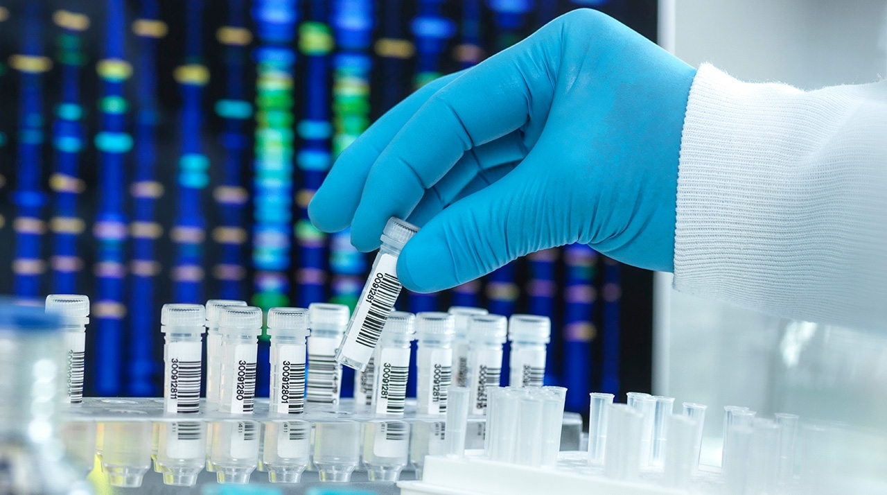 a gloved hand with test tubes in a lab setting
