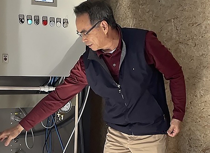 USDA’s Biological Scientist Xikui Wei standing in front of portable steam treatment system