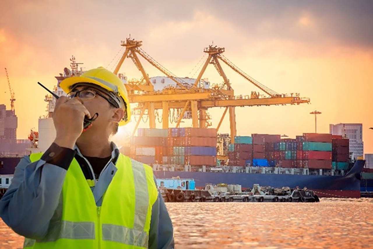 worker at port talking into a walkie talkie